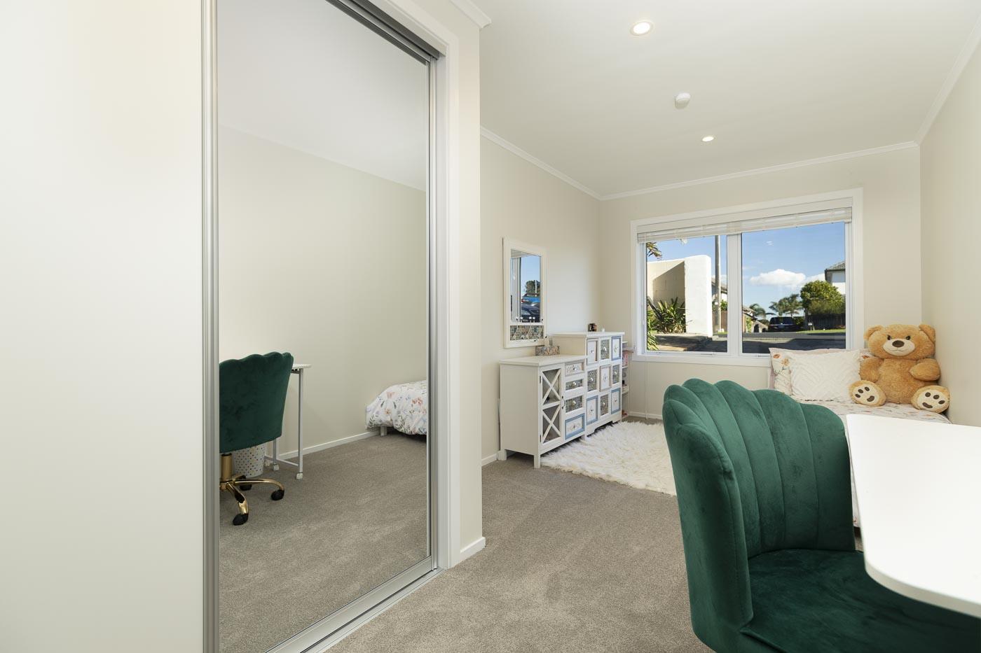 A renovated bedroom with built-in mirrored wardrobe, new carpet and a window seat.