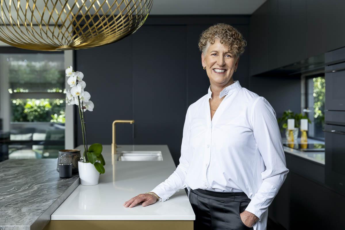 Maree de Latour standing beside a kitchen island in a renovated Auckland home.